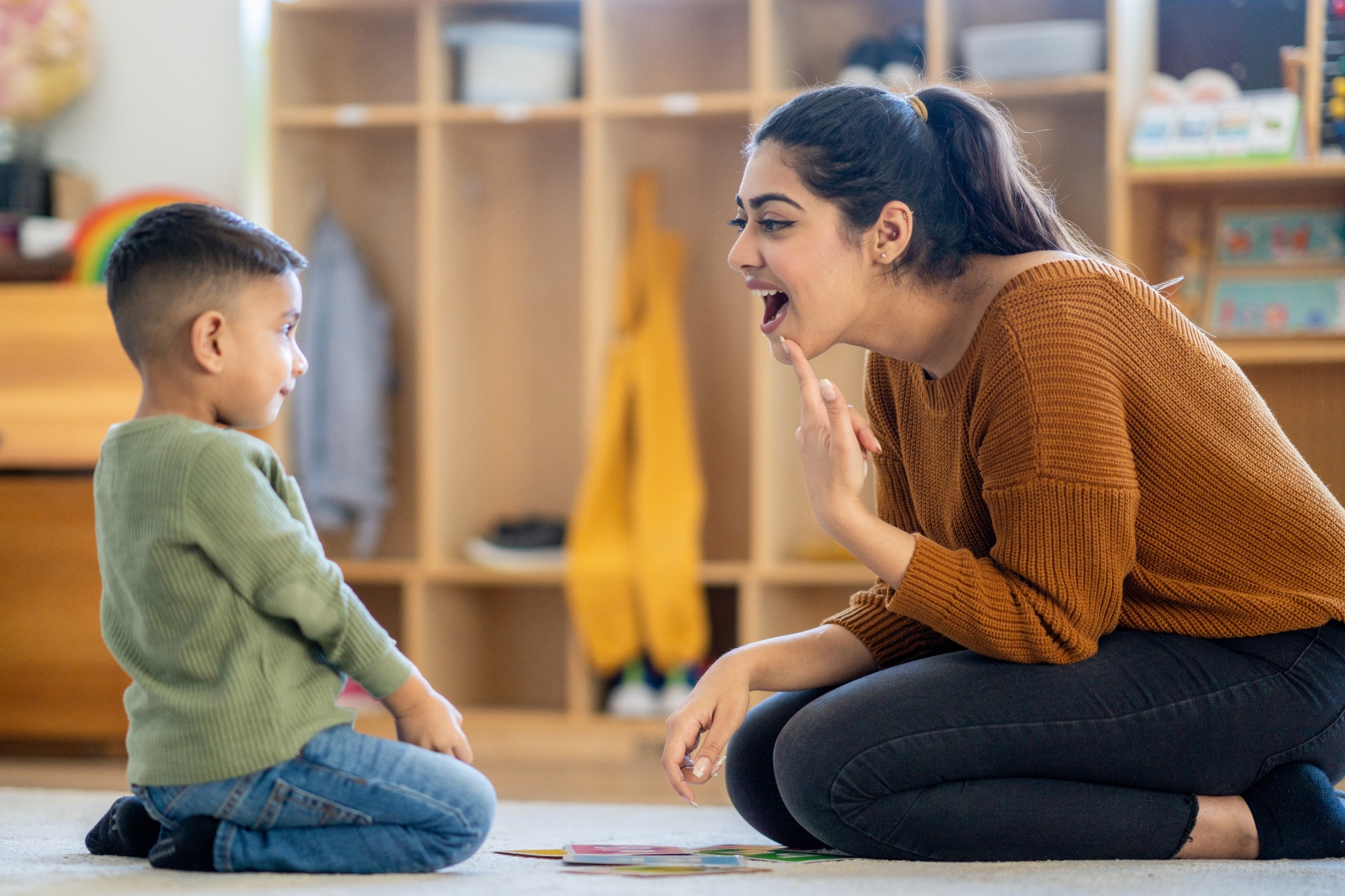 A woman practicing behavior therapy with a little boy at Summit Autism Center.